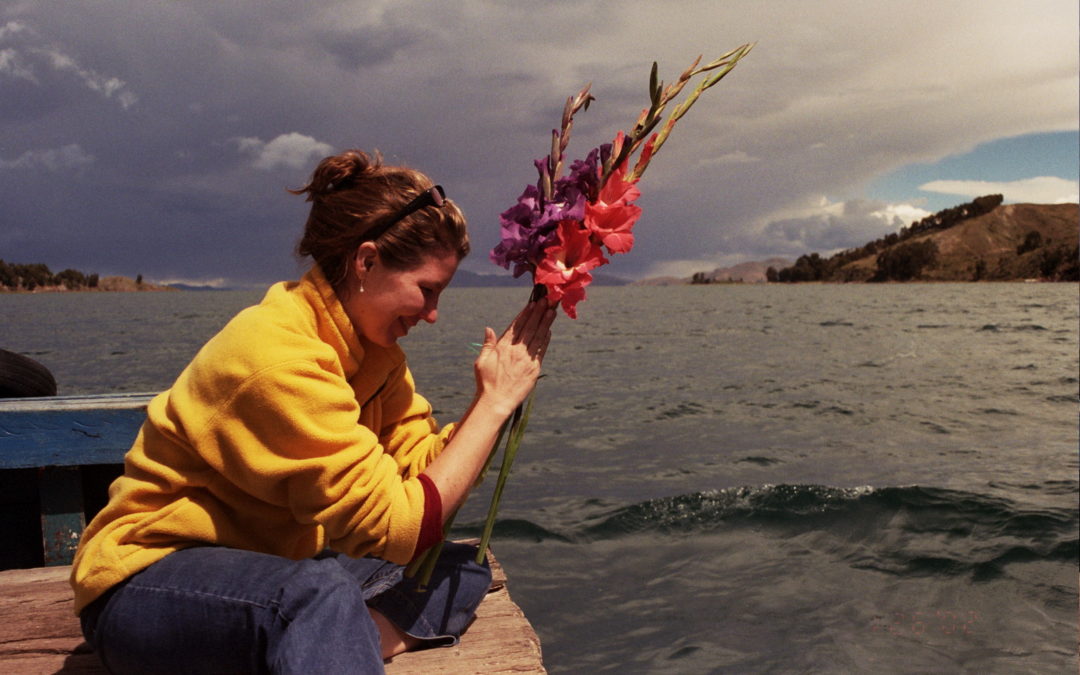 Kerry Hughes, M.Sc. meditating on a dock with surrounding water.